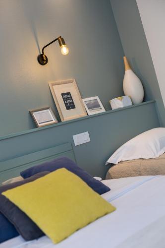 a bedroom with a bed and a shelf with pictures at Cit'Hotel Les Alizes in Dinard