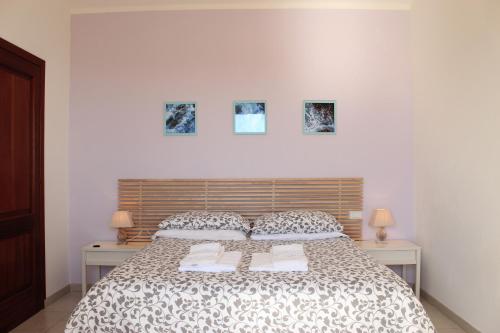 a bedroom with a bed with two tables and two pictures on the wall at Villa Antonini in Lerici