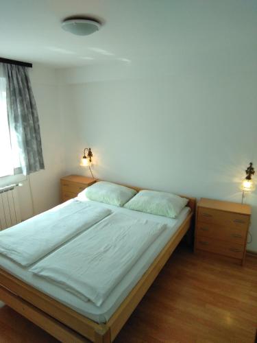a bed in a bedroom with two night stands and a window at Guesthouse Blazenka Hodak in Seliste Dreznicko