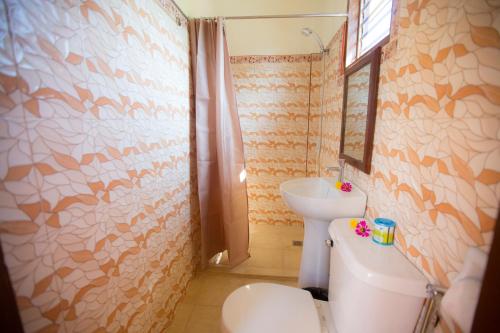 a bathroom with a toilet and a sink at Chekesh Casa in Siquijor