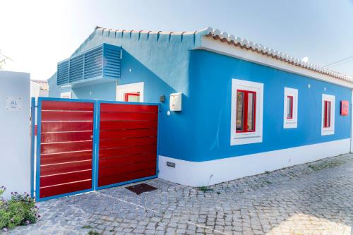 a blue and red house with a red gate at Cercas Velhas in Sagres