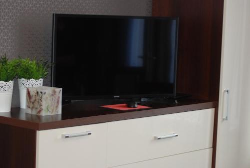 a flat screen tv sitting on top of a dresser at Łeba Apartament in Łeba