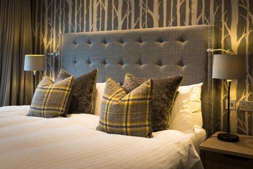 a bedroom with a large bed with two pillows at Auchrannie Resort in Brodick
