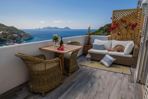 balcón con mesa, sillas y vistas al océano en Maridea Casa Vacanza- Le Alcove sul Mare Suites, en Ponza