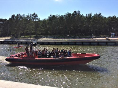 a group of people on a red boat in the water at Łeba Apartament in Łeba