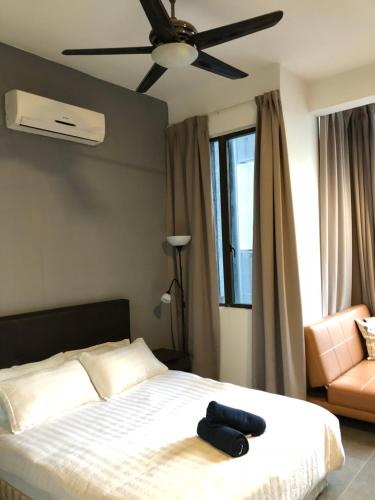 1 dormitorio con 1 cama con ventilador de techo y silla en Empire Damansara Residence Suites en Petaling Jaya