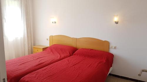 レスタルティットにあるRocamaura I-C-6-3のベッドルーム1室(赤いシーツ付きのベッド1台、窓付)