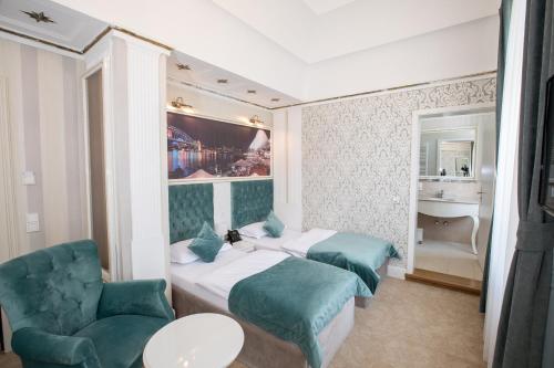 una habitación de hotel con 2 camas y una silla en Hotel Amts-Apotheke en Limburg an der Lahn