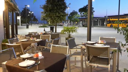 a restaurant with tables and chairs and a yellow bus at Hotel Belvedere in Venice-Lido