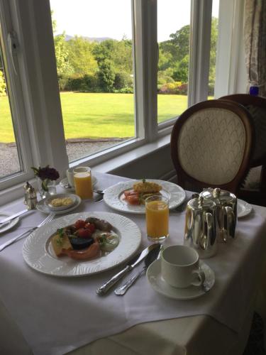 una mesa con platos de comida y zumo de naranja en Lyzzick Hall Hotel, en Keswick
