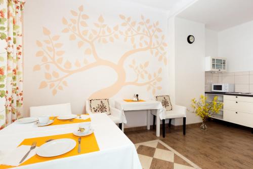 a dining room with two tables and a tree mural on the wall at Pštrossova Vila - u klášterní zahrady in Bechyně