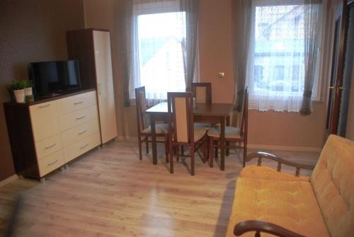 a living room with a couch and a table and chairs at Łeba Apartament in Łeba