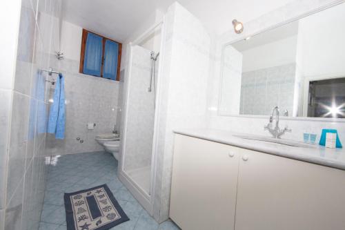 uma casa de banho branca com um lavatório e um WC em casa la Rosa dei venti em Marciana