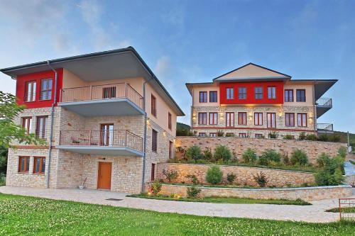 two story houses with red doors on a brick wall at Arktos Hotel in Ioannina