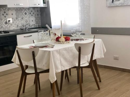 uma mesa de jantar com uma toalha de mesa branca e copos de vinho em Temporary House de' Giudei em Bolonha