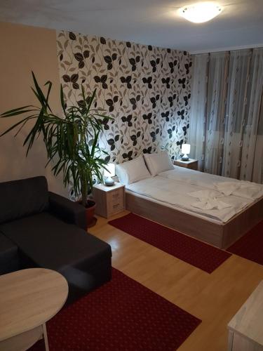 uma sala de estar com uma cama e um sofá em Coral Apartman em Pécs