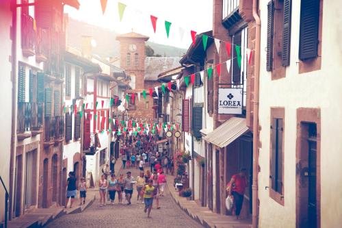 a group of people walking down a street with flags at Gite Botiga in Saint-Jean-le-Vieux