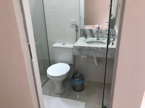 a small bathroom with a toilet and a sink at Pousada Xero in Capitólio
