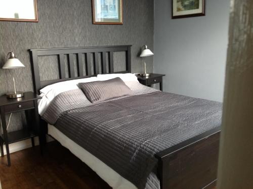 ein Schlafzimmer mit einem großen Bett mit zwei Nachttischen in der Unterkunft Les Hautes Loignieres in Pré-en-Pail