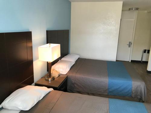 a hotel room with two beds and a lamp at Inn Of Long Beach in Long Beach