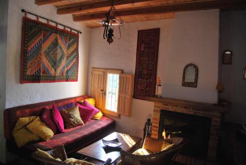 a living room with a couch and a fireplace at Casas Azahar-Alucema in Zahara de la Sierra