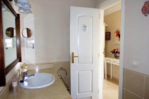 een witte badkamer met een wastafel en een spiegel bij Holiday home Los Frailes in Puerto de la Cruz