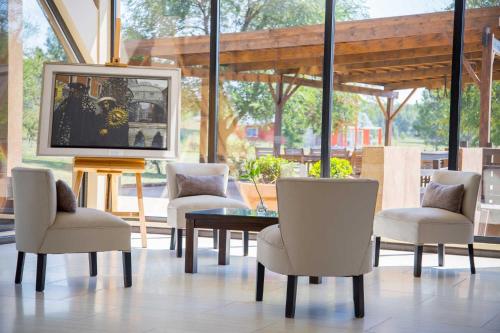a room with a table and chairs and a tv at Ayres del Champaqui Hotel Boutique Experiencial & Spa in Villa General Belgrano