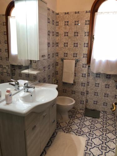 uma casa de banho com um lavatório e um WC em Villa Margherita em Cannigione