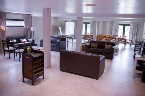 a living room with couches and chairs and a piano at Ayres del Champaqui Hotel Boutique Experiencial & Spa in Villa General Belgrano