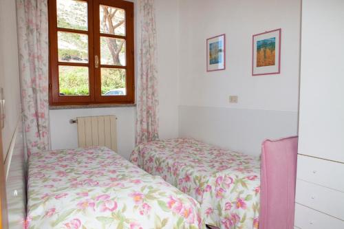 a bedroom with two beds and a window at Casa Danilo in Chiessi