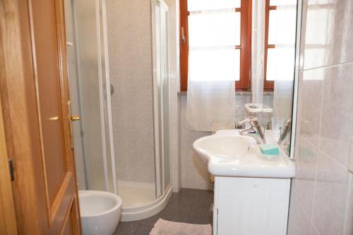 a white bathroom with a sink and a shower at Casa Danilo in Chiessi