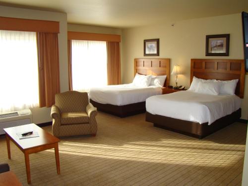 een hotelkamer met 2 bedden en een stoel bij StoneCreek Lodge in Missoula