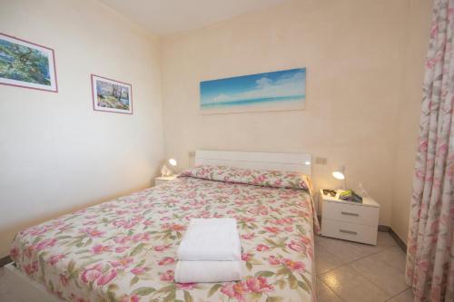 una camera da letto con un letto con copriletto floreale di Casa Danilo a Chiessi