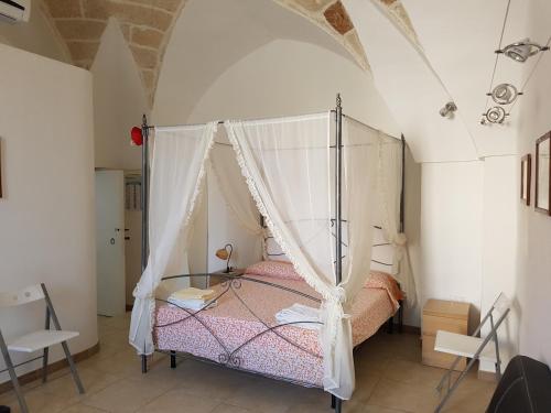 a bedroom with a bed with a canopy at Calì Nitta Storic in Corigliano dʼOtranto