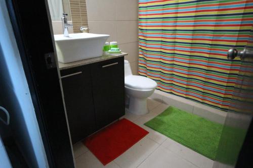 a bathroom with a sink and a toilet and a shower curtain at Playa Blanca Resort in Río Hato