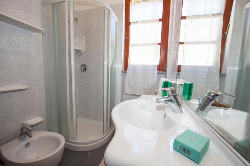 Chiessi的住宿－Casa Danilo，白色的浴室设有水槽和淋浴。