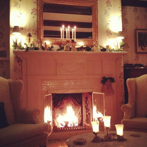 a living room with a fireplace with three candles at Belgravia B&B in Truro
