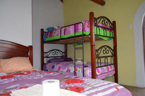 two bunk beds are in a room with at Quilotoa Green Lake in Quilotoa