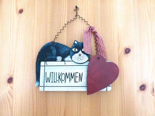 a black and white cat sitting in a box on a wall at Ferienwohnung Paul Schwarzenberg in Schwarzenberg