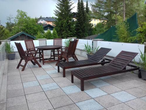 a group of chairs and a table on a patio at Ferienwohnung Wiesmühlstrasse in Henndorf am Wallersee