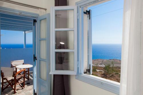 a room with a window with a view of the ocean at Luna Rossa Santorini in Imerovigli