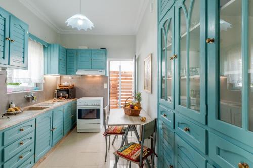 a kitchen with blue cabinets and a counter with a table at Skandalakis Homes & Apartments in Stalos