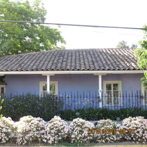 a white house with a blue fence and flowers at Hotel Boutique Quinta Maria in Santa Cruz