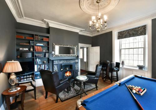 a living room with a pool table and a fireplace at Brockamour Manor Bed and Breakfast in Niagara on the Lake