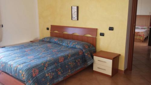 Schlafzimmer mit einem Bett mit blauer Decke und einem Tisch in der Unterkunft Casa Bellavista in Viggianello