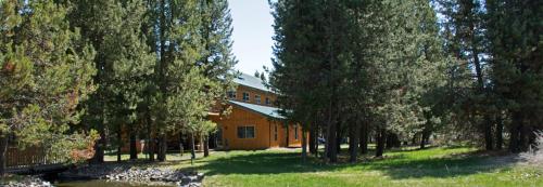 a building with a bunch of trees in front of it at DiamondStone Guest Lodges in La Pine