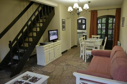 a living room with a staircase and a dining room at Apart Hotel Las Hadas Carilo in Carilo