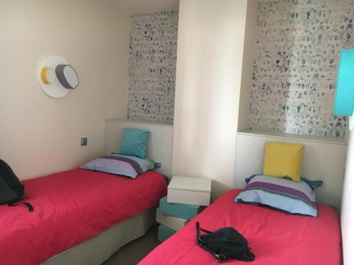 two beds sitting next to each other in a room at Cyrille et Vacances Presqu'ile de la Touques in Deauville