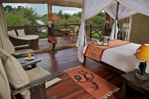 ein Schlafzimmer mit einem Bett und eine Terrasse mit einem Stuhl in der Unterkunft Ashnil Mara Camp in Talek
