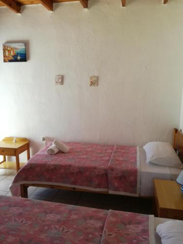a hotel room with two beds and a table at Oasis Hotel Loutro in Loutro